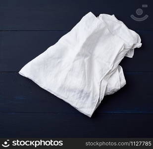 white linen towel on blue wooden background, top view, copy space