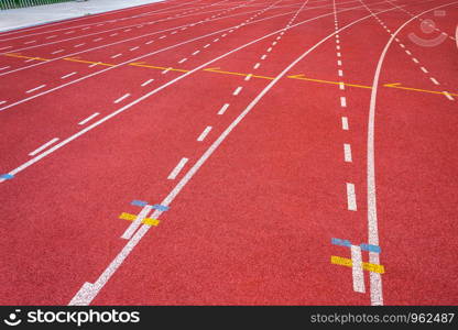 White lines of stadium and texture of running racetrack red rubber racetracks in outdoor stadium are 8 track and green grass field,empty athletics stadium with track,football field, soccer field.