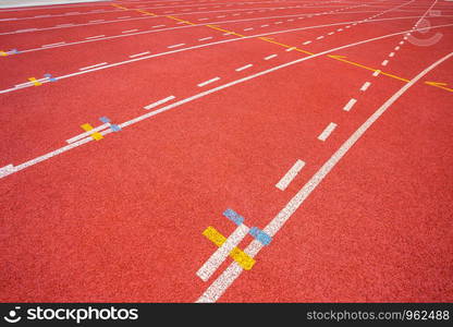 White lines of stadium and texture of running racetrack red rubber racetracks in outdoor stadium are 8 track and green grass field,empty athletics stadium with track,football field, soccer field.