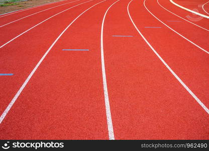 White lines of stadium and texture of running racetrack red rubber racetracks in outdoor stadium are 8 track and green grass field,empty athletics stadium with track,football field, soccer field.