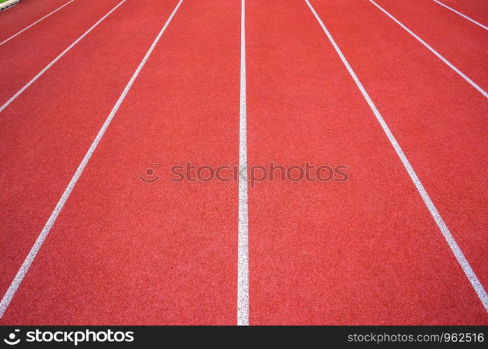 White lines of stadium and texture of running racetrack red rubber racetracks in outdoor stadium are 8 track and green grass field,empty athletics stadium with track,football field, soccer field.