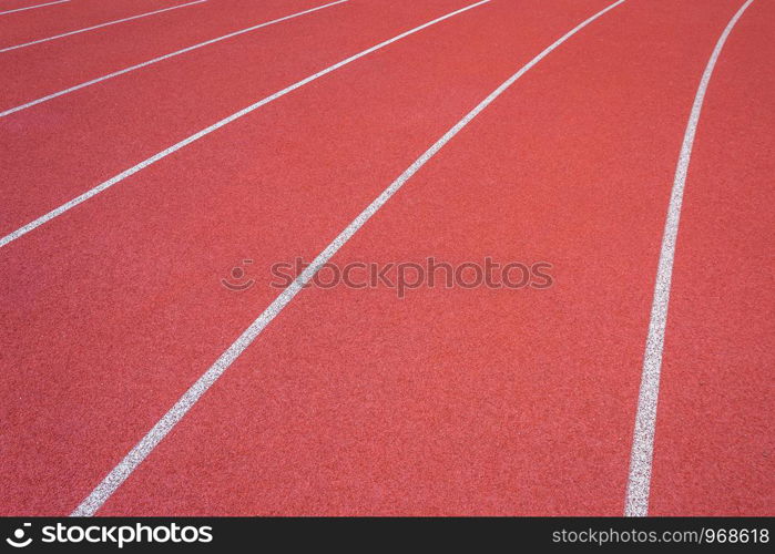 White lines of stadium and texture of running racetrack red rubber racetracks in outdoor stadium are 8 track and green grass field,empty athletics stadium with track.