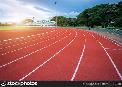 White lines of stadium and texture of running racetrack red rubber racetracks in outdoor stadium are 8 track and green grass field,empty athletics stadium with track.