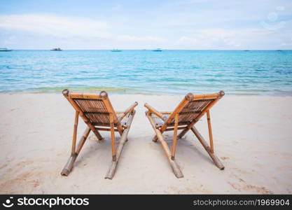 White lounge chairs on beautiful tropical beach at Maldives. White lounge chairs on a beautiful tropical beach at Maldives