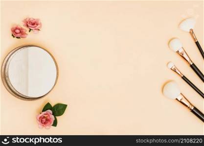 white makeup brushes with compact powder roses colored backdrop