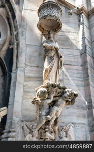 White marble statues on the roof of famous Cathedral Duomo di Milano on piazza in Milan, Italy