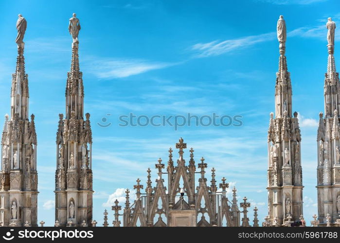 White marble statues on the roof of famous Cathedral Duomo di Milano on piazza in Milan, Italy