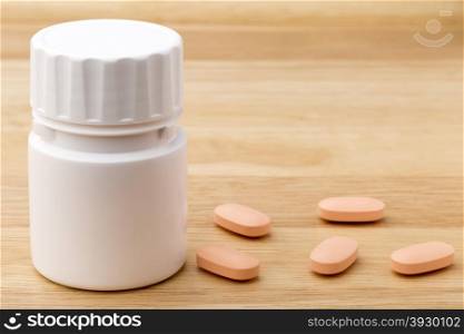 White medicine pills bottle on wooden table background. White pills bottle on wooden table background