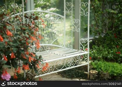 white metal seat chair in flower garden park in spring summer