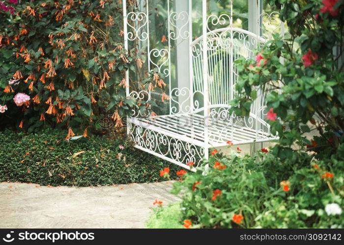 white metal seat chair in flower garden park in spring summer