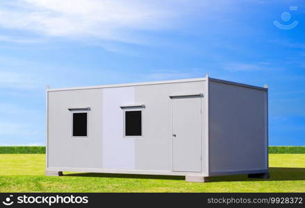 White mobile sandwich panel office container for rent and sale on green lawn with blue sky background