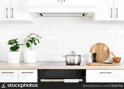 White modern kitchen interior with wooden worktop and kitchenware, culinary concept, background