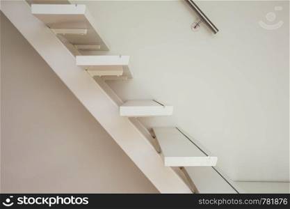white modern wooden Staircase and white wall close-up, house interior. white modern wooden Staircase and white wall close-up