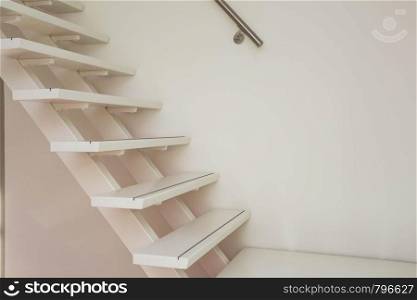 white modern wooden Staircase and white wall close-up, house interior. white modern wooden Staircase and white wall close-up