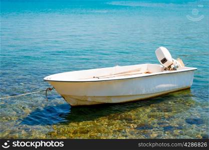 white motor boat tied to the shore