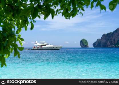 White motor yacht on the background of turquoise water and rocks