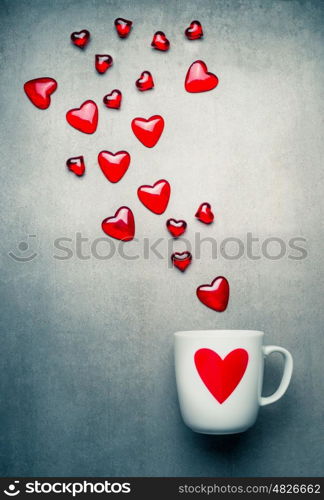 White mug with red heart and flying glass hearts . Love symbols and Valentines day concept, copy space