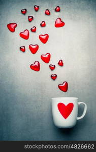 White mug with red heart and flying glass hearts . Love symbols and Valentines day concept, copy space