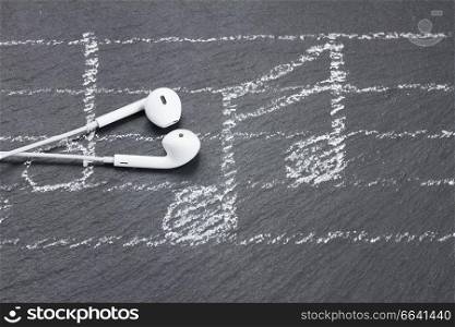 White music notes with white  headphones  on black. Music notes with  headphones 