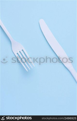 White new clean knife and fork on blue trendy pastel background