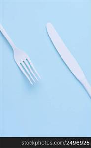 White new clean knife and fork on blue trendy pastel background