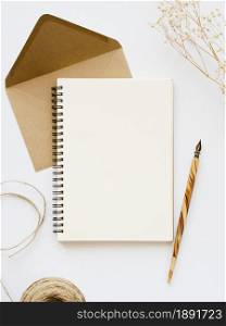 white notebook with wooden nib pale brown envelope with brown thread branch white background. Resolution and high quality beautiful photo. white notebook with wooden nib pale brown envelope with brown thread branch white background. High quality and resolution beautiful photo concept