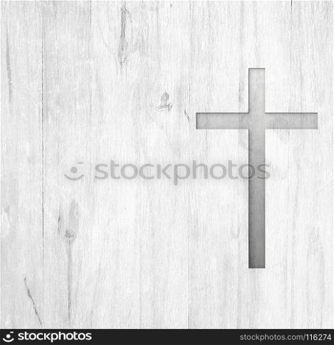 White old christian religion symbol cross shape as sign of belief on a grungy wood textured with copy space.