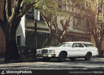 White old classic car parked on the side of the street next to residential house, Coyoacan, Mexico City