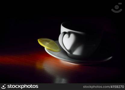 white on saucer cup with lemon in dark
