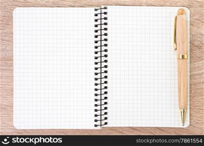 White open notebook and pen on wood background