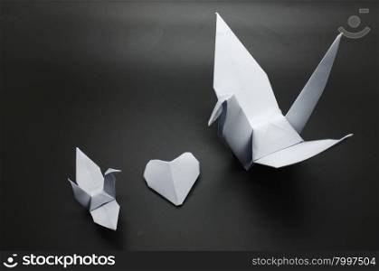 White origami crane and heart between, bird paper