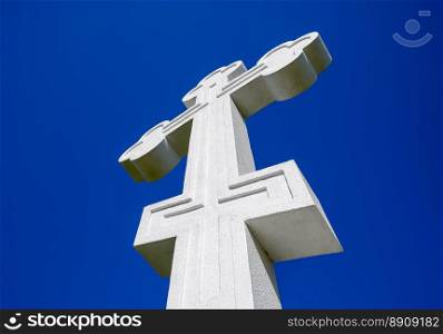 White orthodox christian cross on blue sky background.. White orthodox christian cross on blue sky background