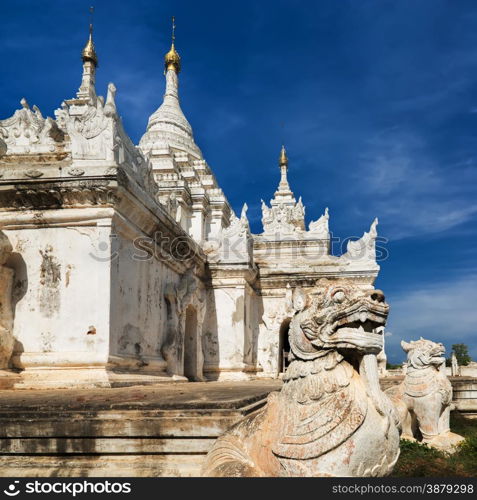 White Pagoda at Inwa ancient city with lions guardian statues. Amazing architecture of old Buddhist Temples. Myanmar (Burma) travel landscapes and destinations