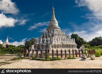 White Pagoda at Inwa ancient city with lions guardian statues. Amazing architecture of old Buddhist Temples. Myanmar (Burma) travel landscapes and destinations