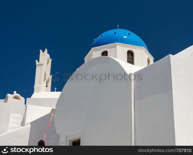 White paint being applied by roller to traditional house in Santorini. Worker repainting traditional cave house on Santorini