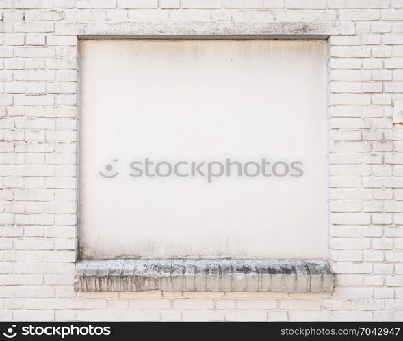 white painted brick wall with blind window of old building