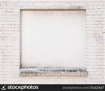 white painted brick wall with blind window of old building