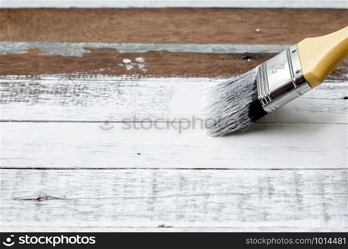 White painted brush on old wood floor.