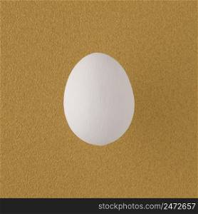 White painted egg on yellow background.
