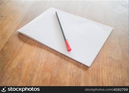 White paper and red pen on wooden table, stock photo