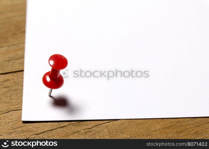 white paper attached to a wooden surface weathered red pin