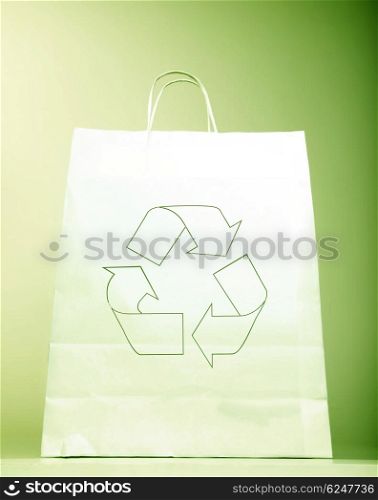 White paper bag with ecology symbol, present with recycle sign isolated on green background, recyclable shopping bag &amp; Eco icon, concept idea to help to save planet earth from pollution