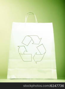 White paper bag with ecology symbol, present with recycle sign isolated on green background, recyclable shopping bag &amp; Eco icon, concept idea to help to save planet earth from pollution