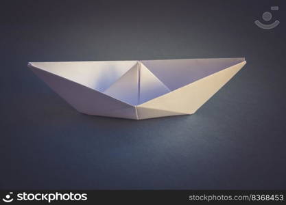 White paper boat origami isolated on a blank grey background.. White paper boat origami isolated on a grey background