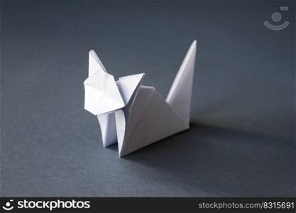 White paper cat origami isolated on a blank grey background.. White paper cat origami isolated on a grey background