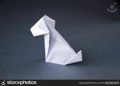 White paper dog origami isolated on a blank grey background.. White paper dog origami isolated on a grey background