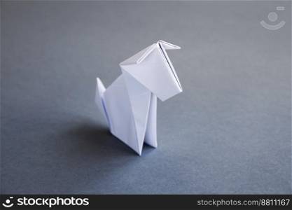 White paper dog origami isolated on a blank grey background.. White paper dog origami isolated on a grey background