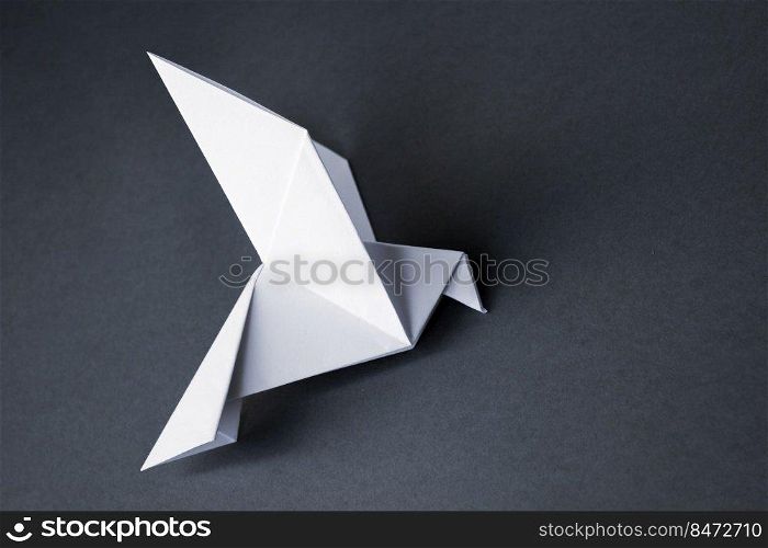 White paper dove origami isolated on a blank grey background.. White paper dove origami isolated on a grey background