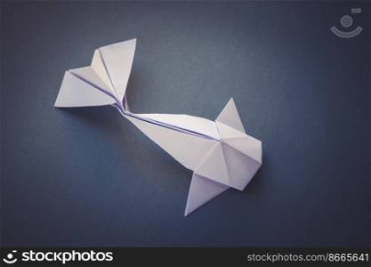 White paper fish origami isolated on a blank grey background. White paper fish origami isolated on a grey background