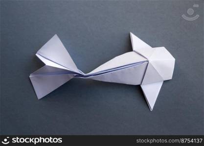 White paper fish origami isolated on a blank grey background. White paper fish origami isolated on a grey background